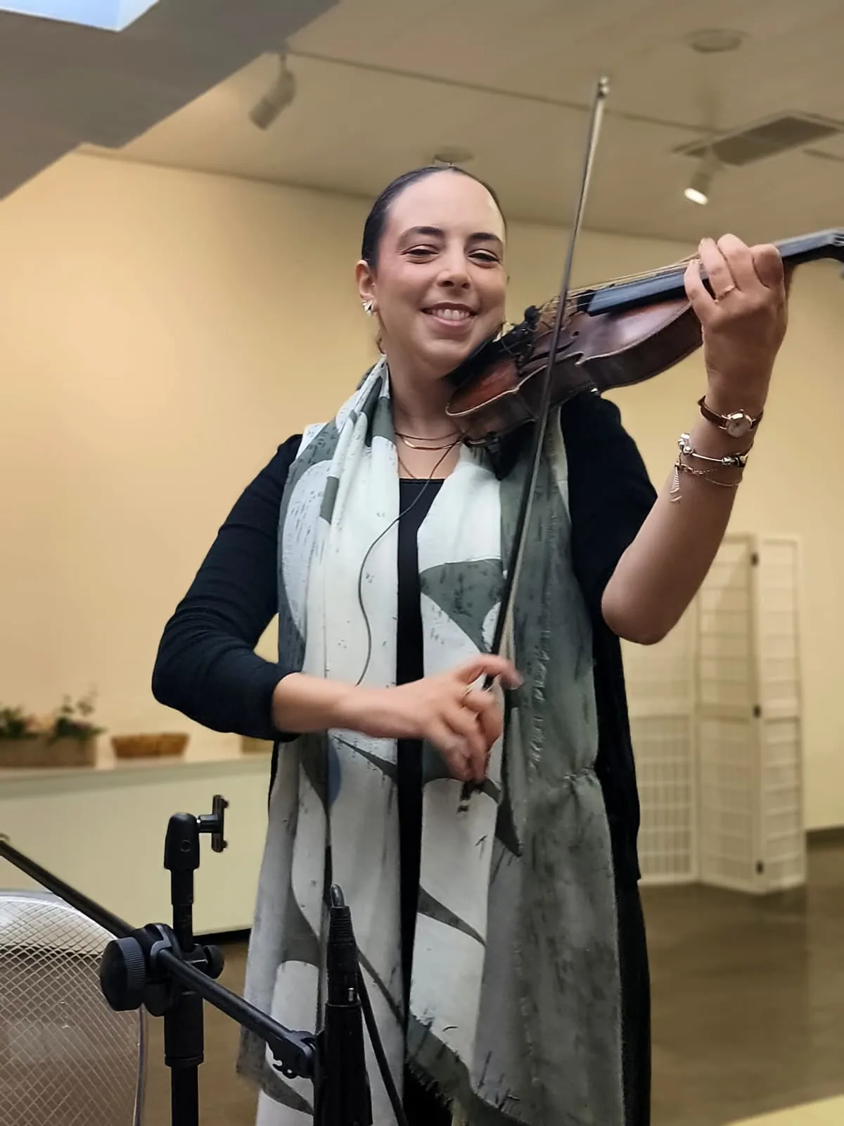 A Joana a sorrir enquanto toca violino, com um lenço ao pescoço