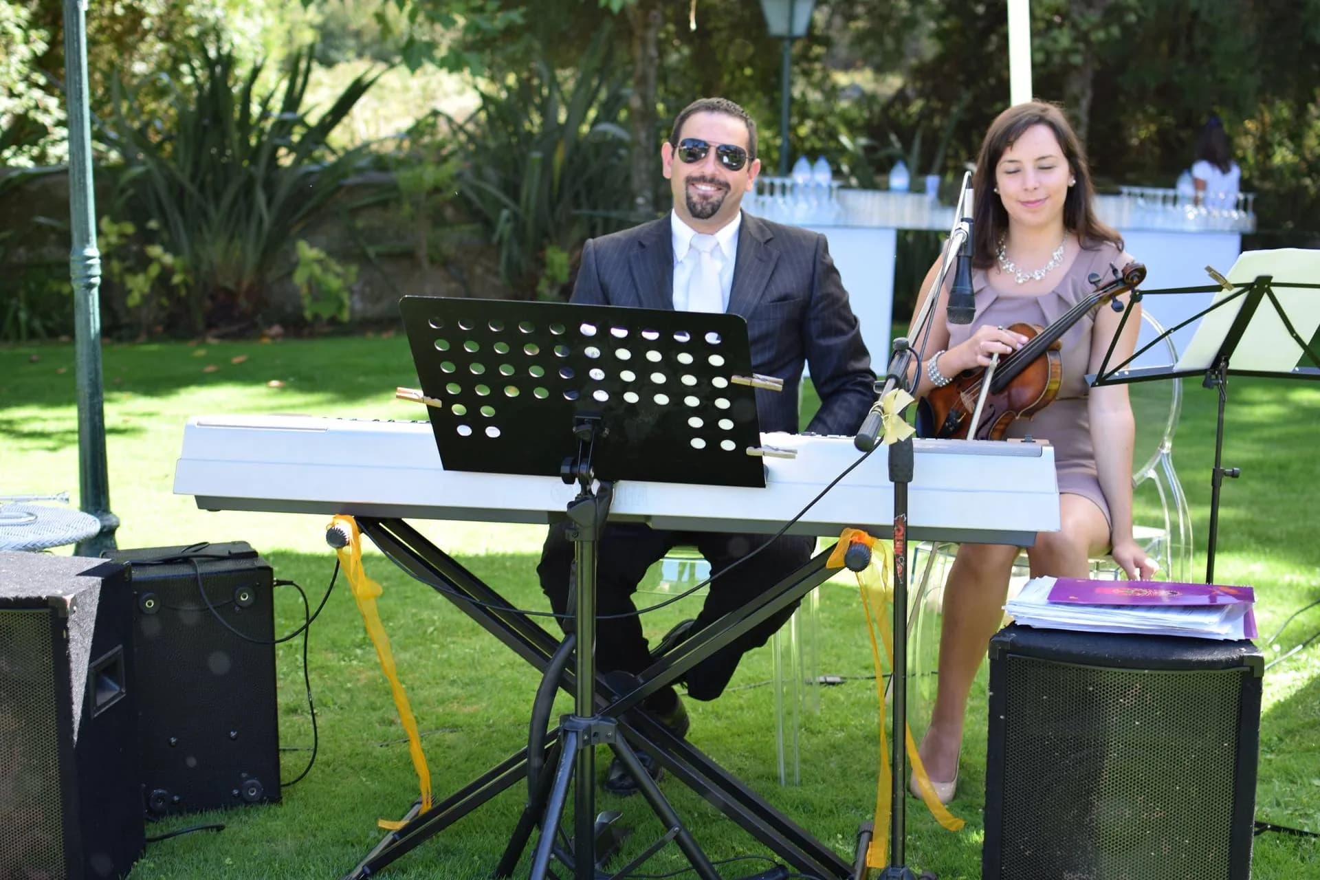 O Nelson ao teclado e a Joana ao violino a atuar num relvado